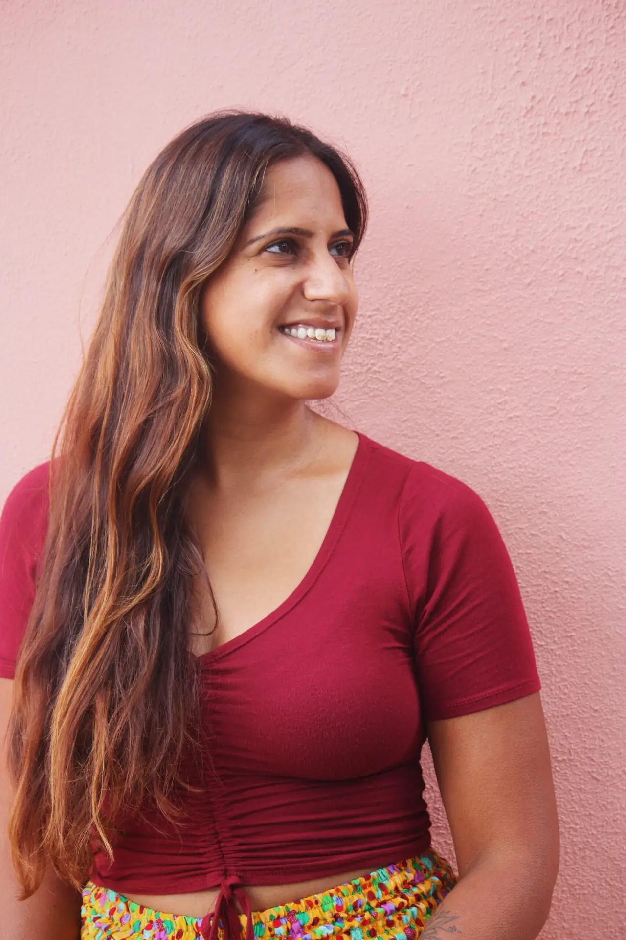 Firdose Moonda in maroon top, colorful skirt.